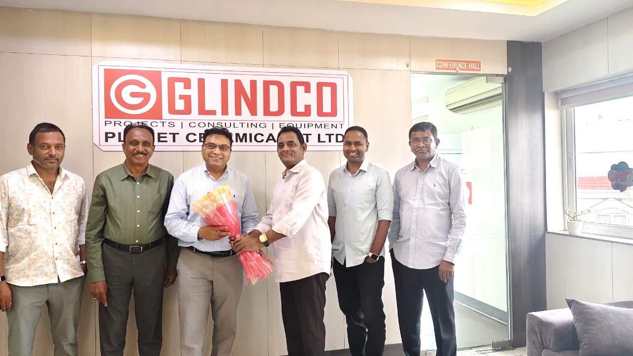 Welcoming Mr. Satish Manduva at GLINDCO corporate office in front of the brand wall sign